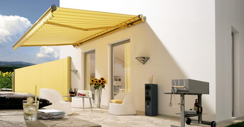 Ein hellgelbes Windschutzrollo schützt eine Terrasse vor störenden Winden